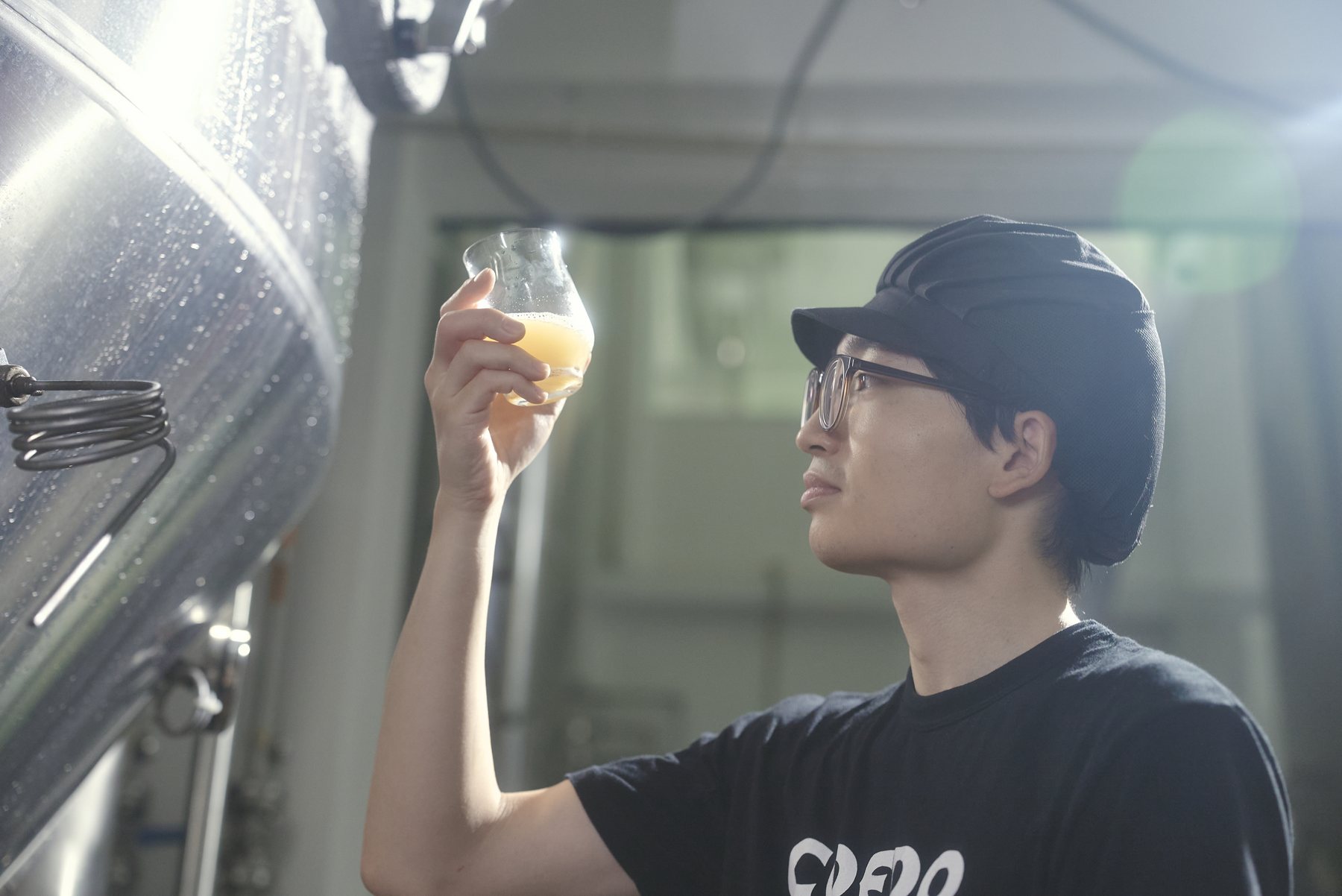 醸造所でビールの液色と香りを確かめる様子